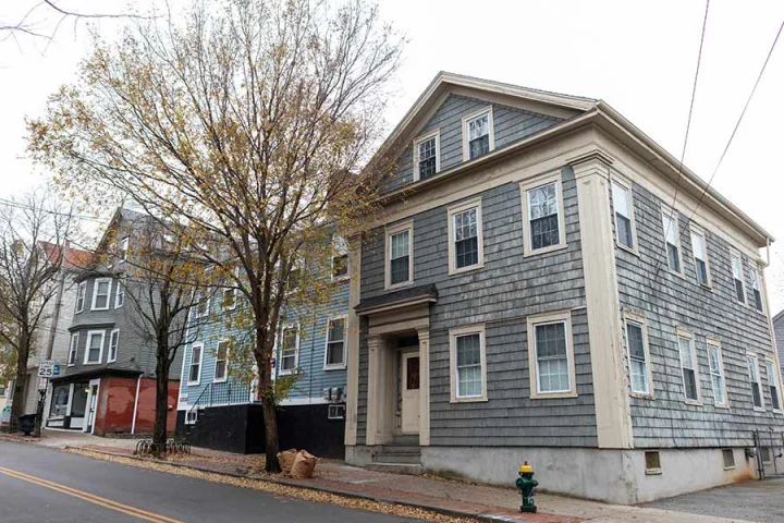 distressed blueish gray home in Providence facing foreclosure in Rhode Island