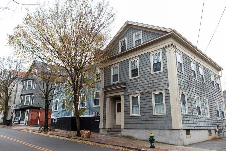 distressed blueish gray home in Providence facing foreclosure in Rhode Island