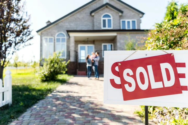 family standing in front of a recently sold house