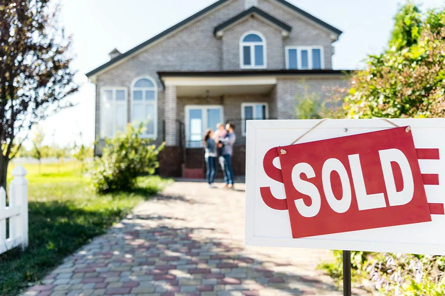 family standing in front of a recently sold house