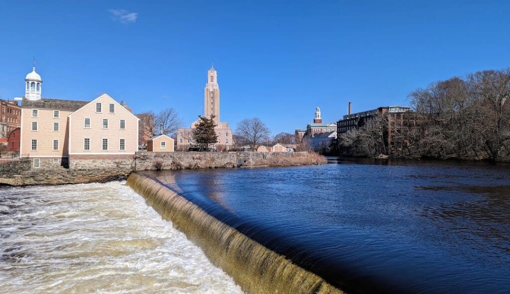 Historic mill buildings and the Blackstone River flowing through Central Falls, Rhode Island, reflecting the city’s industrial heritage.