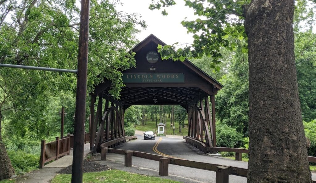 Lincoln Woods State Park covered bridge surrounded by greenery — a popular local destination in Lincoln, Rhode Island.