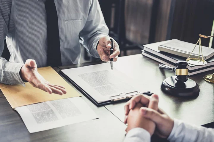 client sitting with male attorney review documents while selling a house during divorce