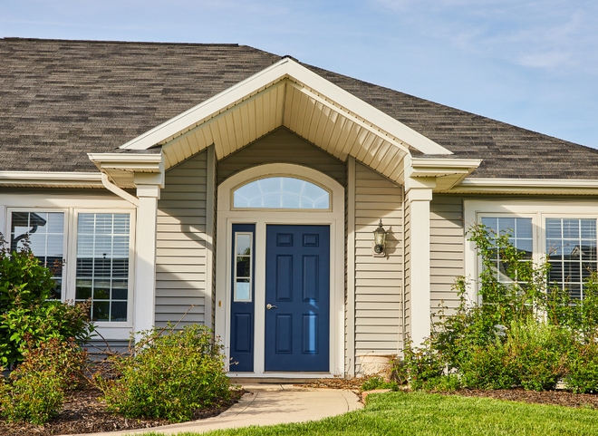Ranch-style home in South Kingstown RI with navy blue front door, taupe siding, and manicured landscaping