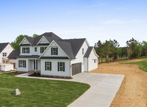 Modern white farmhouse with attached garage and long concrete driveway in Narragansett, RI — We Pay More Properties buys homes for cash