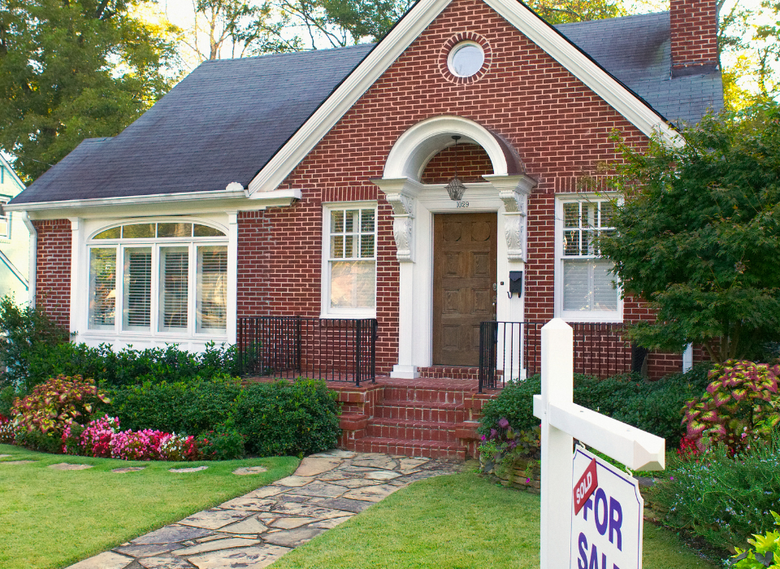 Brick Tudor cottage with sold sign in Mount Pleasant, Providence RI — sell your home fast for cash with We Pay More Properties