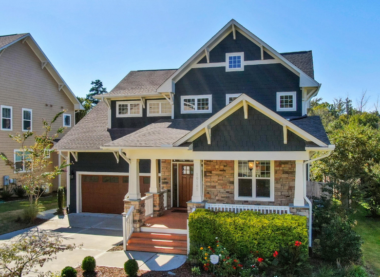 Dark gray Craftsman home with stone accents and covered porch in North Smithfield, RI — sell your house fast for cash with We Pay More Properties