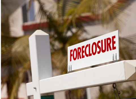 Foreclosure sign on white real estate post in front of Rhode Island home — We Pay More Properties helps homeowners stop foreclosure with a fast cash sale