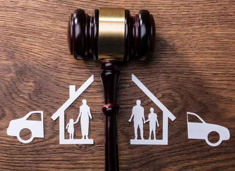 Judge's gavel splitting paper cutouts of family, house, and car in Rhode Island divorce — We Pay More Properties helps divorcing couples sell their home fast for cash