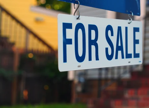 For Sale sign hanging in front of Rhode Island property with squatters — We Pay More Properties buys homes with squatter situations as-is