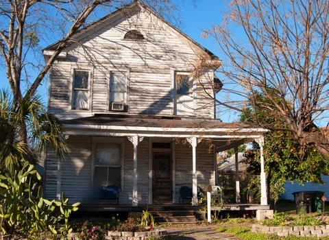 Severely deteriorated two-story Victorian home with peeling paint and sagging porch in Rhode Island — avoid cash home buyer scams and get a fair offer from We Pay More Properties